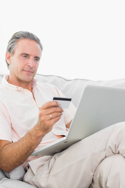 istock Man on his couch using laptop for shopping online 847371754