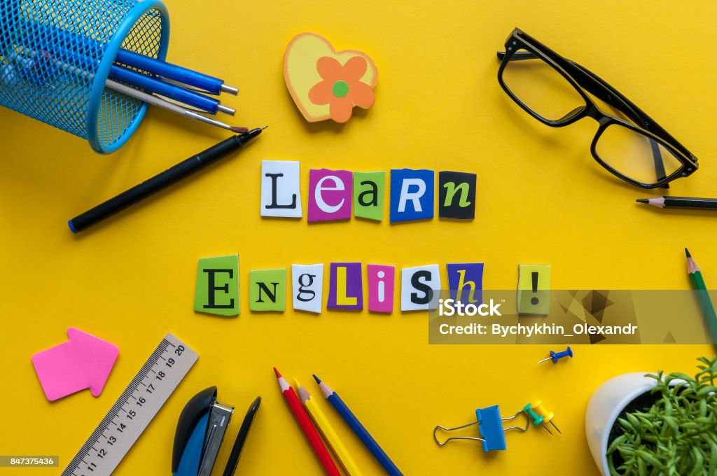 單詞學習英語用雕刻的字母 onyellow 辦公桌與辦公室或學校用品、 文具。英語語言課程的概念 - 免版稅英語圖庫照片