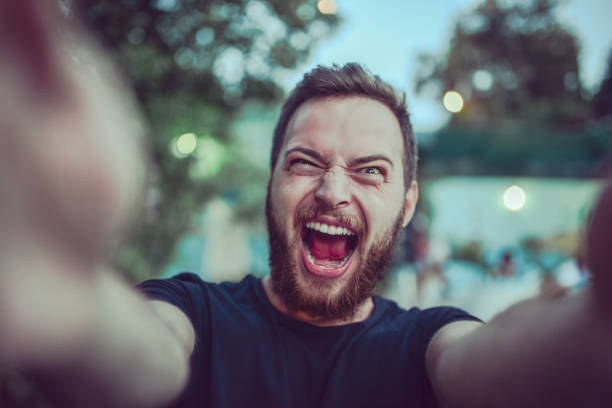 미친 남자 복용 selfie 비명과 야외에서 얼굴을 만들기 - humor men laughing teenager 뉴스 사진 이미지
