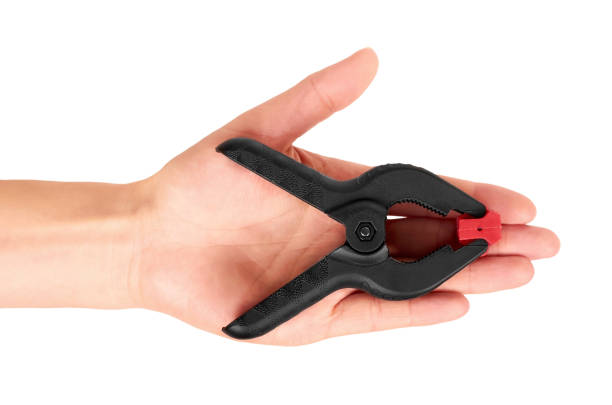 istock Black plastic clamp in hand isolated on white background 847383444