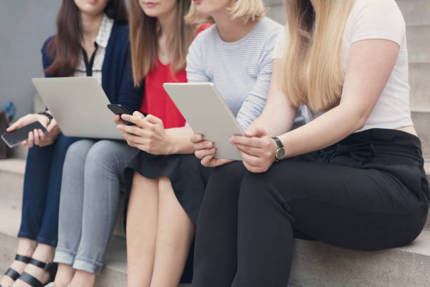 istock Young women working with technologies while they are sitting on the stairs 847404058