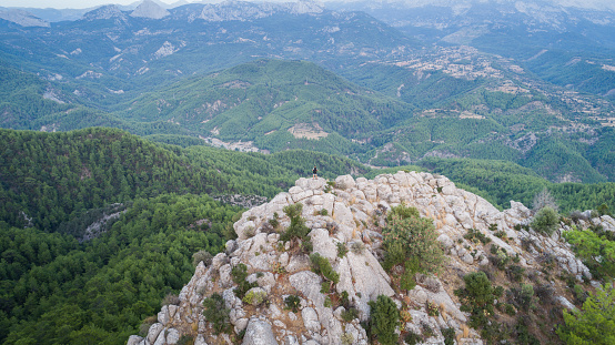 Traveler with backpack looks on a mountain peak aerial view photography