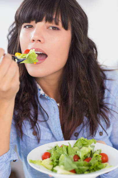 istock Pretty brunette eating a salad for lunch 847404730