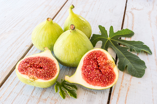 Ripe sweet figs with green leaves. Healthy mediterranean fig fruit.