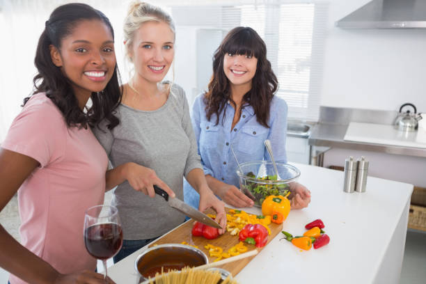 istock Cheerful friends preparing a meal together looking 847407406
