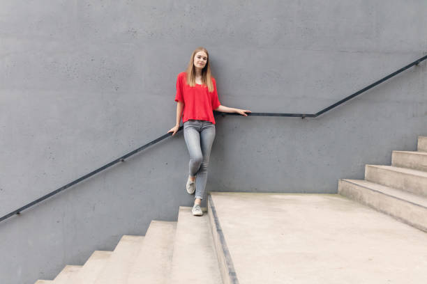 istock Young woman standing on stairs by concrete wall 847408070