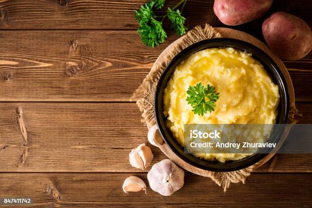 Mashed Potatoes With Butter And Fresh Parsley In Bowl On Rustic Wooden Table Stock Photo - Download Image Now