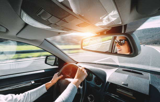 istock Woman drive a car reflects in back view mirror 847412578