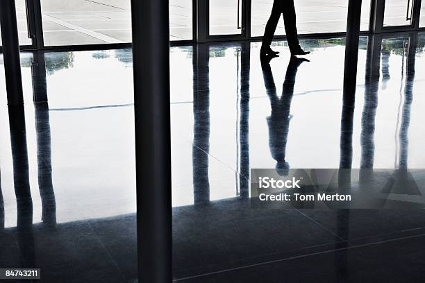 Reflejo De Hombre De Negocios Caminando En La Oficina Del Lobby Foto de stock y más banco de imágenes de Oficina