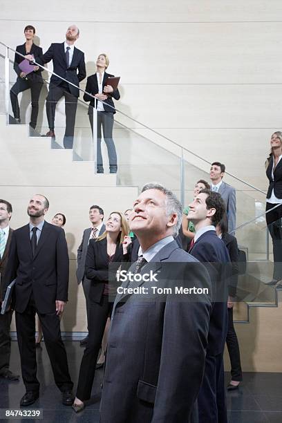 Businesspeople Looking Up In Office Lobby Stock Photo - Download Image Now - Admiration, Business, Leadership
