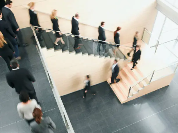 Photo of Businesspeople walking down office staircase