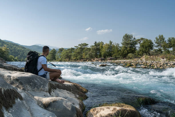 istock Traveler with backpack looks on a waterfall 847432998
