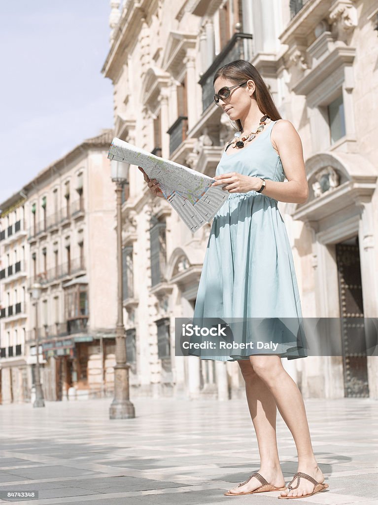 Donna guardando la mappa nella urban plaza - Foto stock royalty-free di Carta geografica