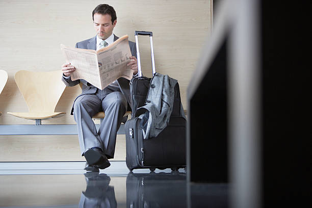 Businessman waiting in airport  newspaper airport reading business person stock pictures, royalty-free photos & images