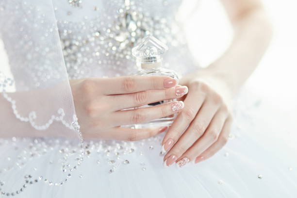 신부 손에 향수 병입니다. 여자는 그녀의 결혼식을 위해 준비 됩니다. 우아한 웨딩 드레스, 아름 다운 신부 손에 매니큐어 - perfume wedding bride spraying 뉴스 사진 이미지