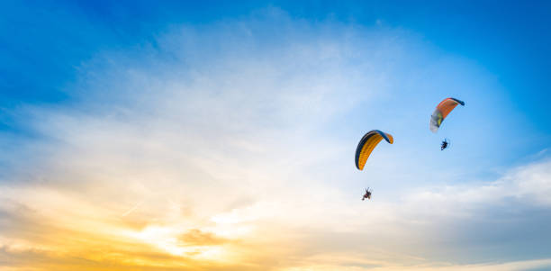 fundo do céu por do sol com paramotor - airplane sky extreme sports men - fotografias e filmes do acervo