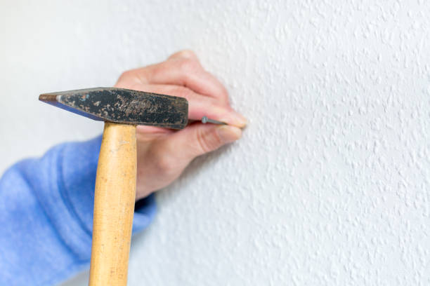 istock Hammer a nail into a white wall close up 847469744