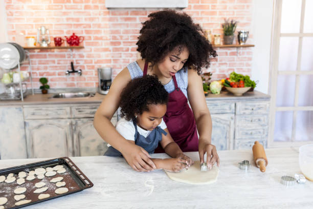 istock Mother and daughter using metal molds for making homemade biscuits 847484026