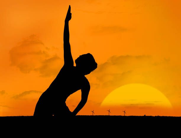 istock Silhouette of woman doing yoga under sunset 847487320