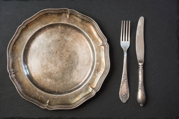istock Empty vintage metal plate with silverware on black, with copy space for your menu or recipe. Menu card for restaurants. 847496692