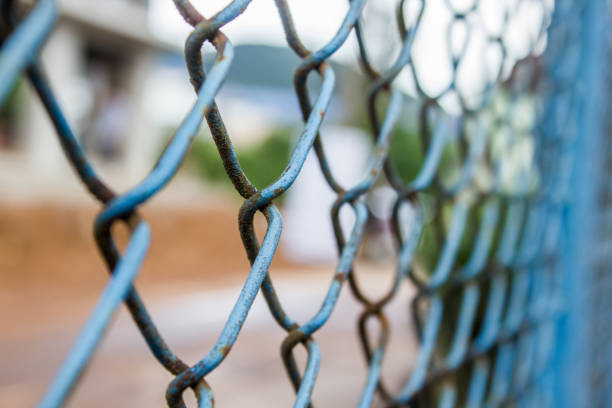 istock Close up old rusty blue chain link fence. Metal mesh. Selective focus 847503062