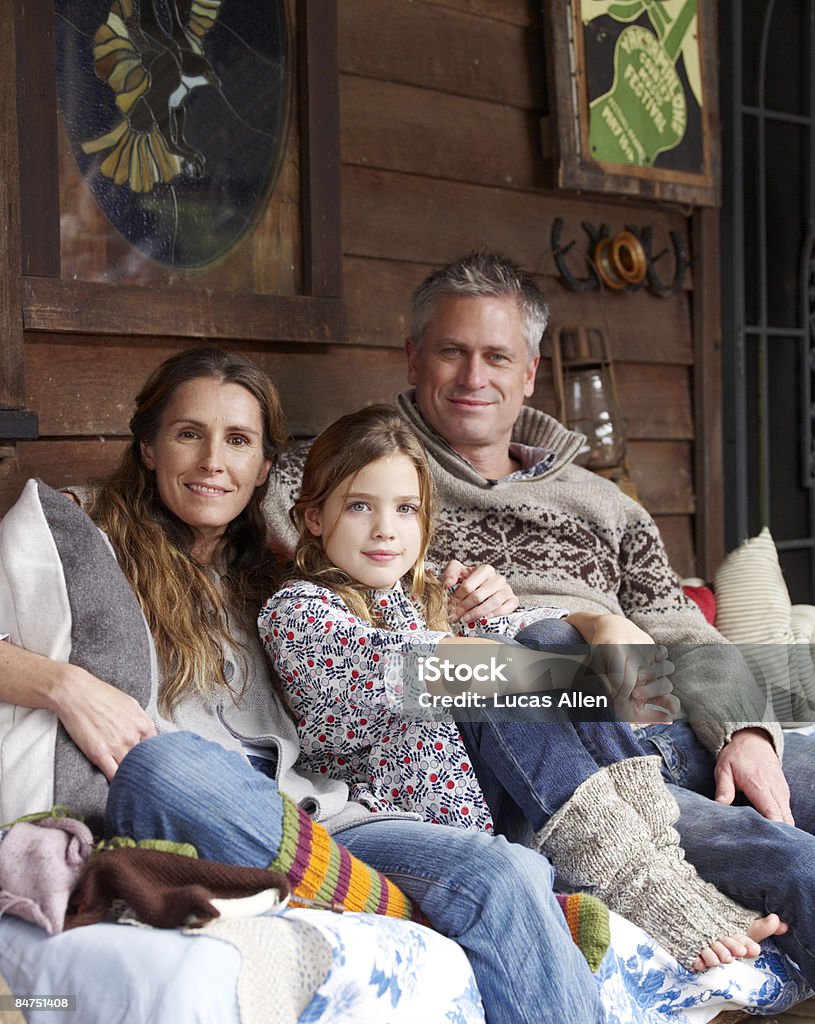 Family on porch outside country home  Family Stock Photo