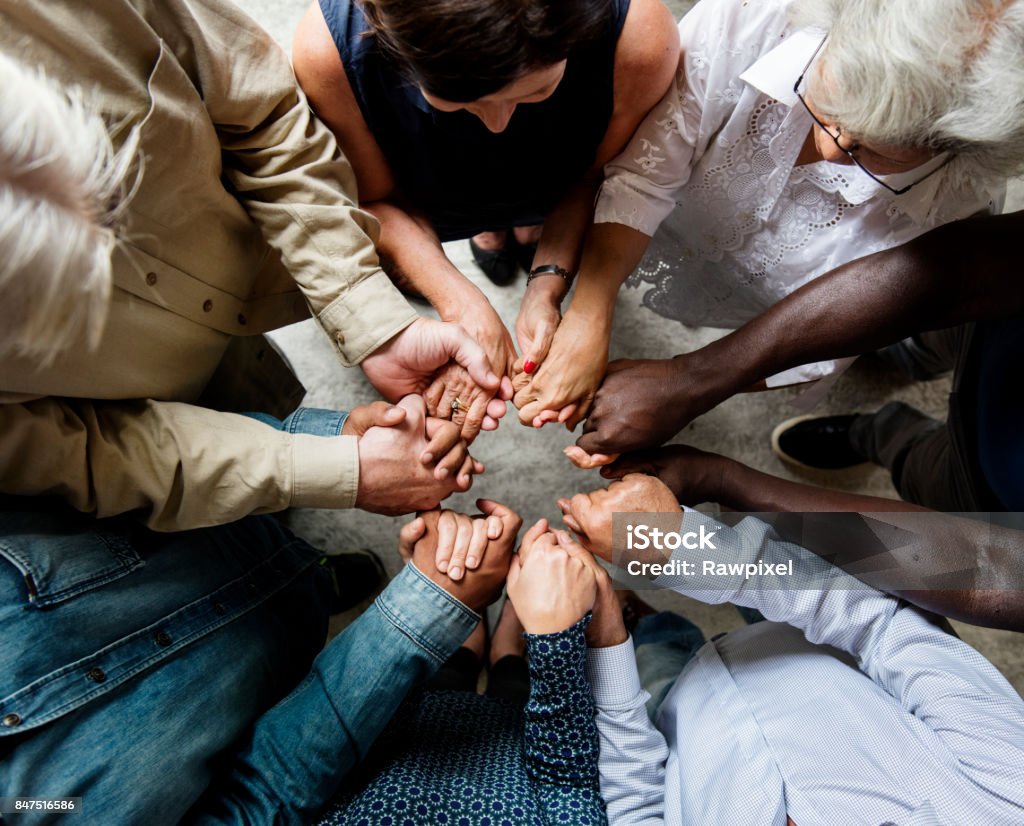 Group of diverse hands holding each other support together teamwork aerial view ***NOTE TO INSPECTOR: Please re-submit again.*** Praying Stock Photo