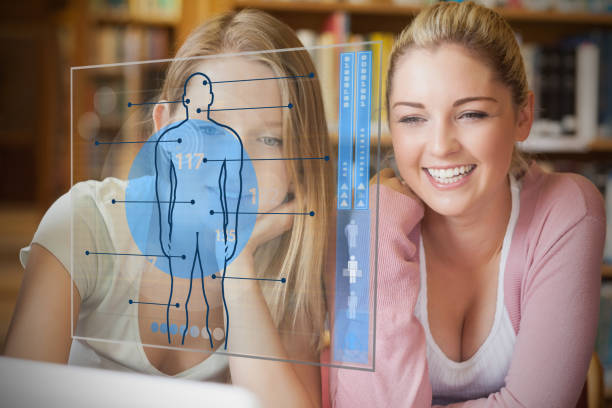 istock Two college students looking at laptop and futuristic interface with body diagram 847535240