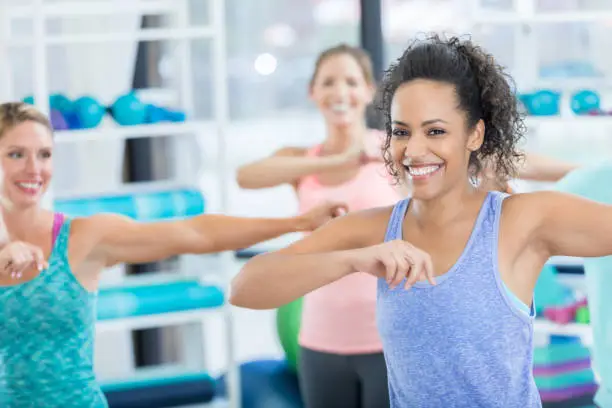 Photo of Cheerful young woman smiles for camera during dance class