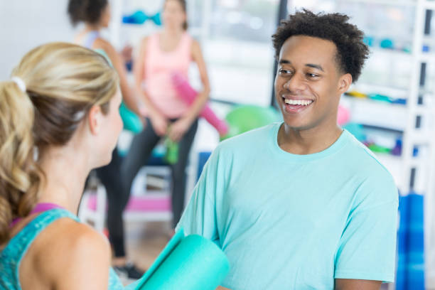 istock Cheerful young man talks with female exercise classmate at gym 847535680