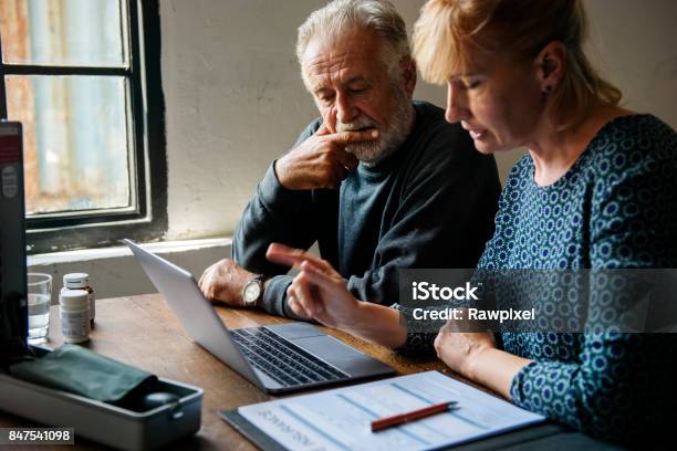 Elderly Couple Planning On Life Insurance Plan Stock Photo - Download Image Now - Life Insurance, Decisions, Planning