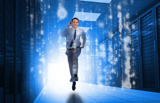 Businessman running through data center with glowing computer matrix