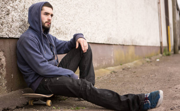 istock Skater sitting on his board looking thoughtful 847546740