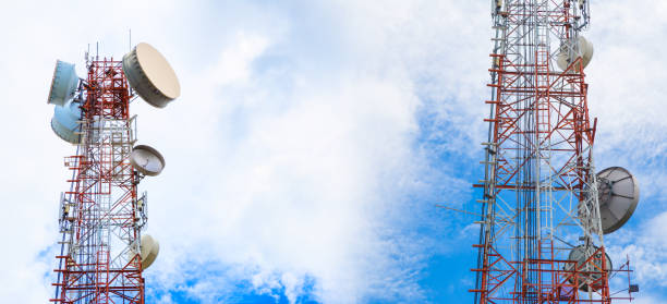 large telecommunication towers against bright blue sky with white clouds, wireless communication business concept, room for text or copy space