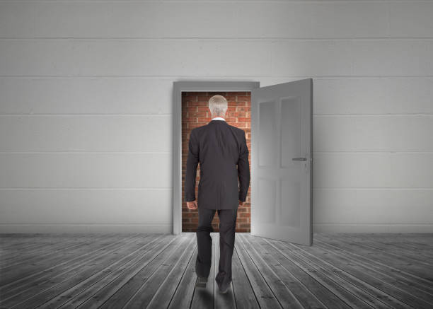 istock Businessman walking towards door open but blocked by red brick wall 847563708