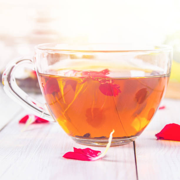 istock Floral black tea, honey can, petals on a white wooden table. 847568680