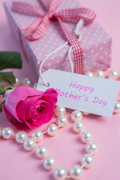 Pink rose with gift and string of pearls for mothers day
