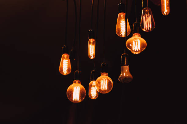 istock hanging dim vintage style tungsten light bulb on dark background loft style lighting decoration concept 847574938