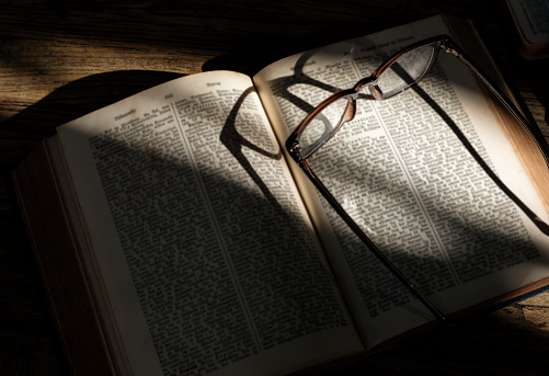 Closeup of holy bible with eyeglasses on