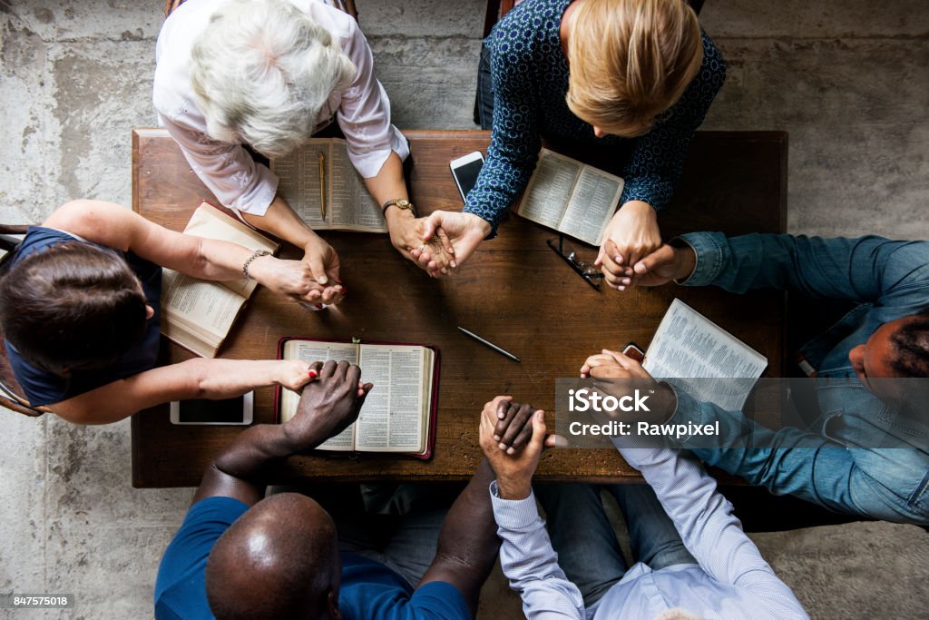 Gruppo di persone che si tengono per mano pregando culto credere - Foto stock royalty-free di Pregare