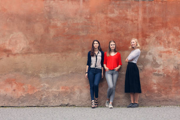 istock Three confident young women standing on a red wall 847584946