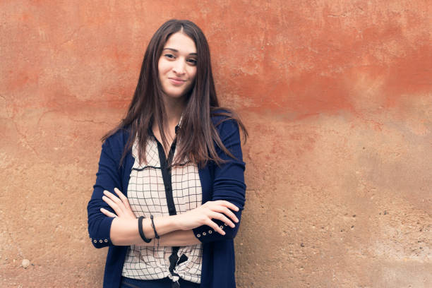 istock Confident young woman standing on a red wall 847585232