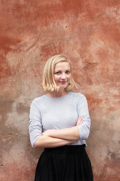 istock Confident young woman standing on a red wall 847585846