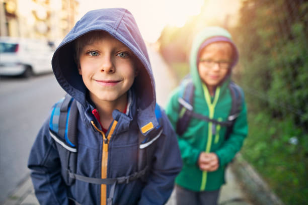Two boys are walking to school on a cold September morning.