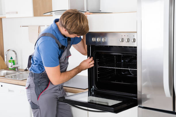 istock Repairman With Screwdriver Fixing Oven 847606264