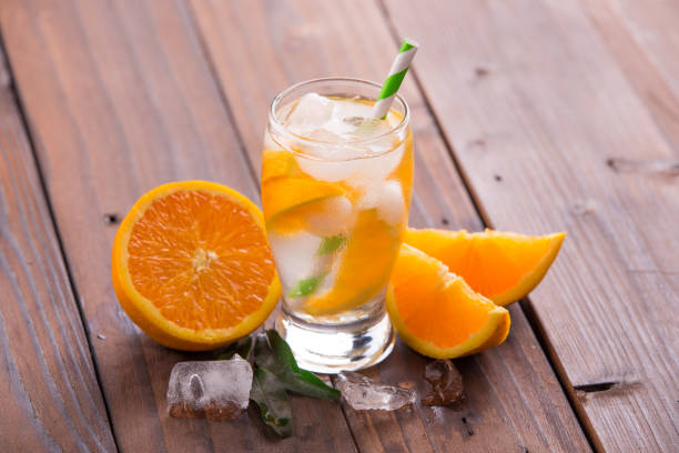 istock Orange cocktail on brown wooden background 847617992