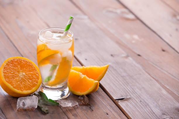 istock Orange cocktail on brown wooden background 847618262