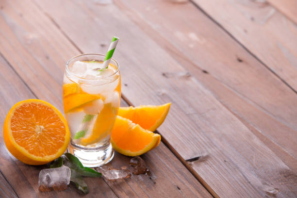 istock Orange cocktail on brown wooden background 847618398