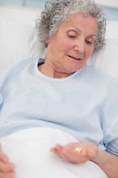 istock Patient looking at drugs in her hand 847620882