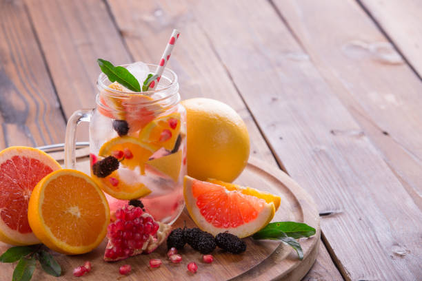 istock Refreshing sangria / punch with orange, pomegranate seeds, blackberry, and grapefruit on brown rustic wooden background 847622082